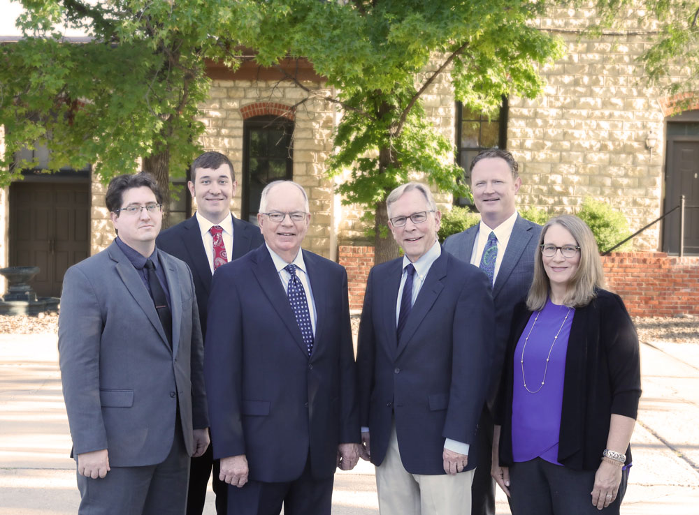 Adrian & Pankratz attorneys standing in front of the Old Mill building in Newton, Kansas